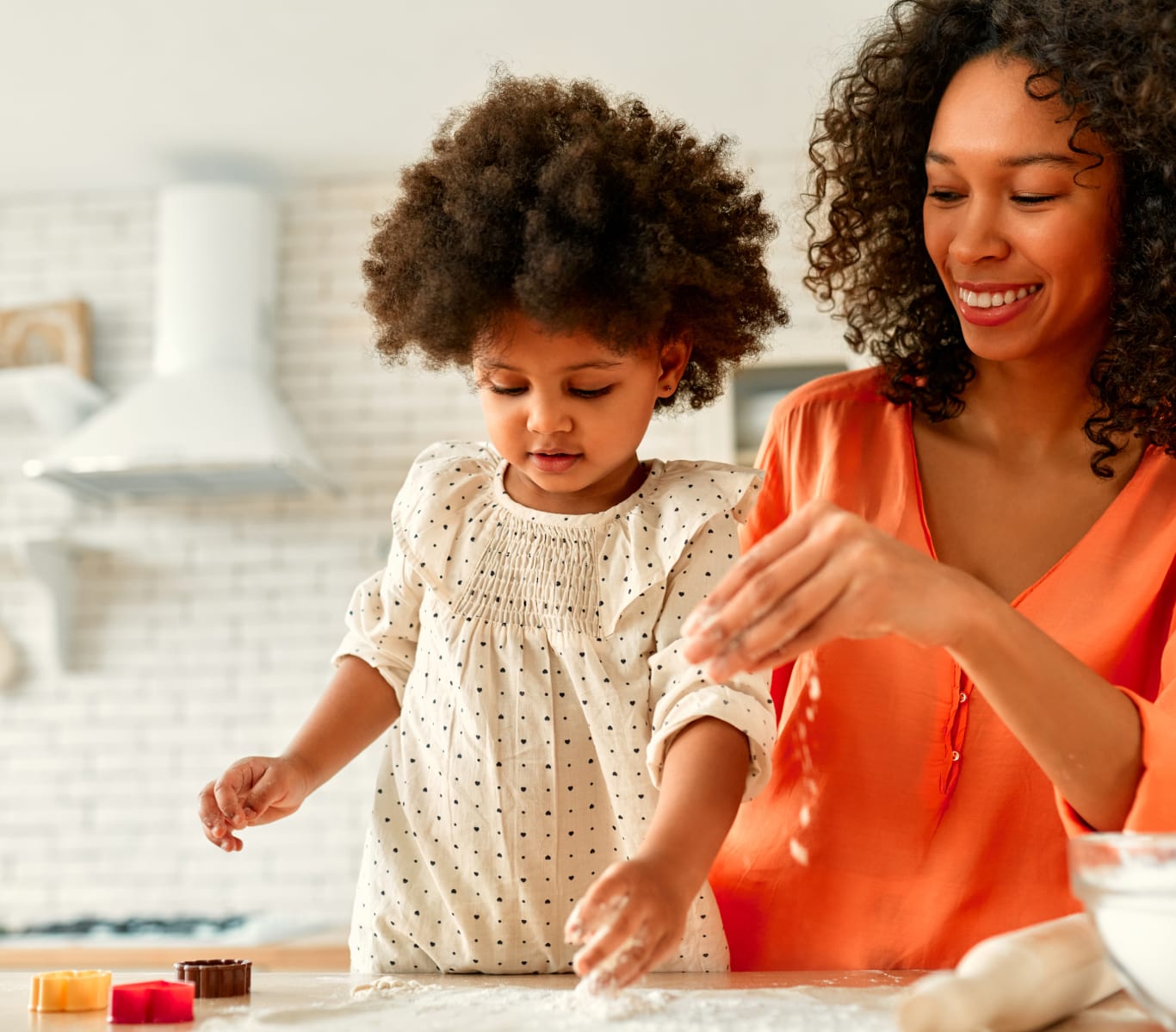 Mother and daughter baking, playing with flour on a countertop