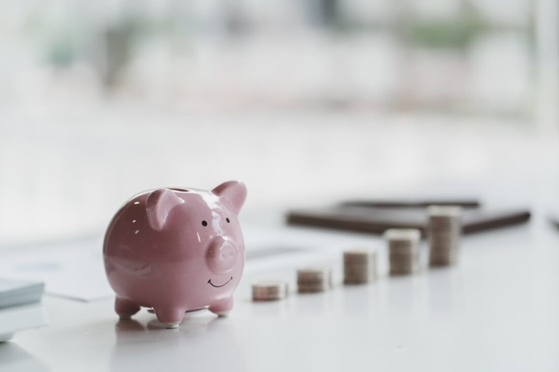 Piggy bank and stack of coins on a table